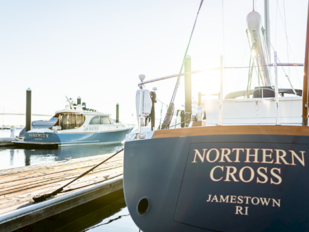 A docked sailboat named Northern Cross at Jamestown, RI, with a smaller yacht nearby on calm waters. End.